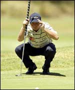 Tim Clark eyes up a putt during his first round