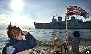 Youngster peers through binoculars as the Ark Royal leaves the port