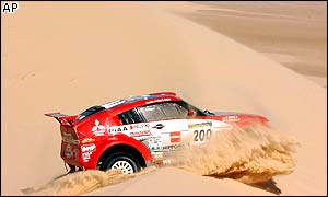 Japan's Hiroshi Masuoka rides over a sand dune