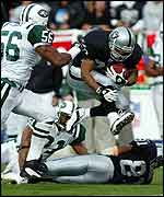 Raiders running back Charlie Garner leaps over team-mate Tim Brown