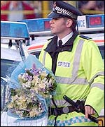 A policeman delivers a tribute for Mr Oake