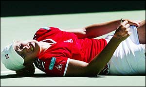 Justine Henin-Hardenne falls to the floor in pain