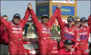 Hiroshi Masuoka and Andreas Schulzt celebrate with third-placed Stephane Peterhansel and Jean-Paul Cottret