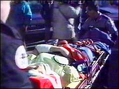 Paramedics rush a victim of the shooting to an ambulance