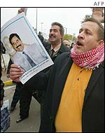 Supporter demonstrates with picture of Saddam Hussein