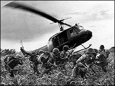 Helicopter taking off, leaving troops on ground