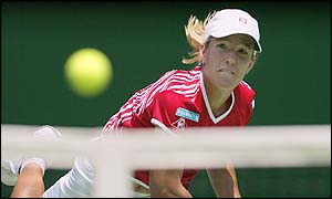 Justine Henin-Hardenne serves over the net