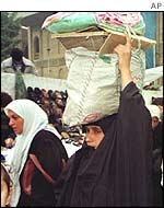 A woman collects her food rations in Baghdad
