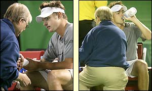 Andy Roddick is treated by the trainer during a three minute injury time-out at the end of the second set