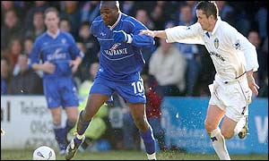 Gillingham's Guy Ipoua is held back by Leeds United's Gary Kelly 
