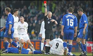 Referee Neale Barry shows Mark Viduka of Leeds the red card
