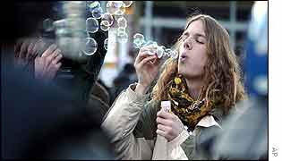 Protester blows soap bubbles at riot police in Landquart, near Davos