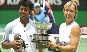Paes and Navratilova hold the winners trophy aloft as well as cuddly toys