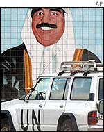 UN vehicle in front of a mural of Saddam Hussein