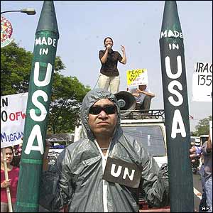 Demonstrator in Manila dressed up UN arms inspectors holding mock missile
