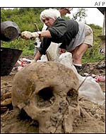 Forensic scientist examines mass grave
