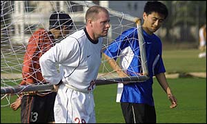 Gazza carries the goalposts off the pitch after a training session with Liaoning team of China 