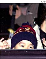 The youngest refugee waves at the press