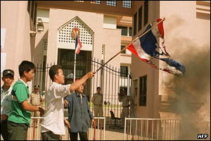 Man burning a flag outside the Thai embassy in Phnom Penh