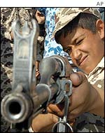 Iraqi child aims a machine gun