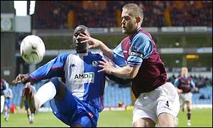 Andy Cole tussles with Olof Mellberg