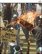 Protesters burn the French flag