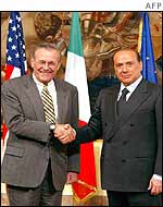 Donald Rumsfeld (left) shakes hands with Italian Prime Minister Silvio Berlusconi (right)
