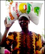 A woman carrying a sack of maize on her head