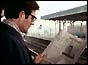 Man reading new Times edition at train station