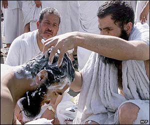 A pilgrim shaves another's head after the stoning the devil ceremony