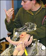  An Israeli soldier explains to expectant parents how to place a newborn baby in a chemical warfare protective kit 