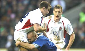 England's Charlie Hodgson, playing his first ever match at centre, is tackled by Gerald Merceron