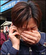 A woman cries as she makes a phone call after the South Korean subway fire