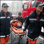 Medics carry an injured person on a stretcher after the South Korean subway fire