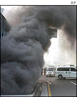 Black smoke rises as ambulances wait ready 