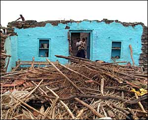 A villager in Madhya Pradesh stands by the remains of her home after floods devastated the area