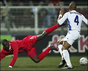 Emile Heskey falls to the floor after a challenge from Alain Boumsong