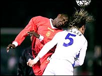 Auxerre's Philippe Mexes challenges Liverpool's Emile Heskey for the ball