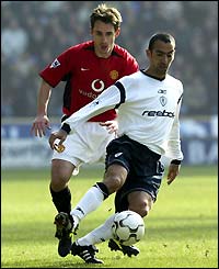 Bolton's Youri Djorkaeff shields the ball from Gary Neville