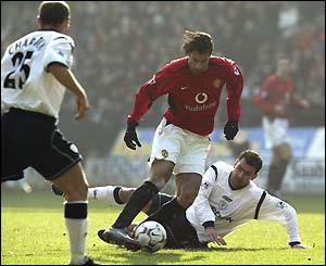 Ruud Van Nistelrooy breaks a tackle from Florent Laville
