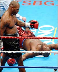 Etienne is counted out by the referee as Tyson struts around him