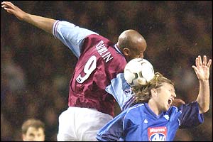 Dion Dublin for Aston Villa gets to grips with Birmingham midfielder Robbie Savage in an aerial challenge