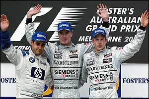 Race winner David Coulthard celebrates on the podium with second placed Juan Pablo Montoya and third placed McLaren-Mercedes team-mate Kimi Raikkonen 