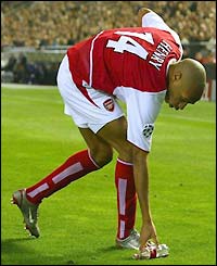 Henry clears away a plastic bottle from the pitch