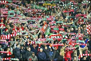Liverpool and Celtic fans wave scarves in the air as they sing 'You'll Never Walk Alone' together