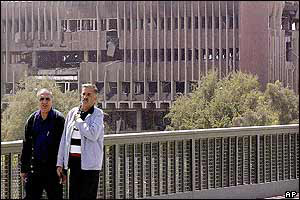 Two Iraqi men walk across a bridge in Baghdad