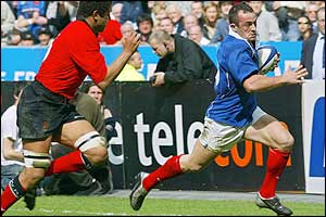 Wales's Colin Charvis tries in vain to stop Thomas Castaignede scoring for France after 27 minutes