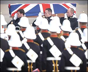 A band from the Royal Marines 3 Commando Brigade in front of the coffin bearing party
