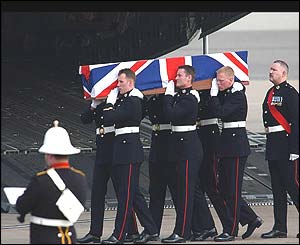 RAF servicemen carry the flag-draped coffin of one of their number