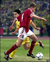 Denmark's Jon Dahl Tomasson evades Romania's Cosmin Contra